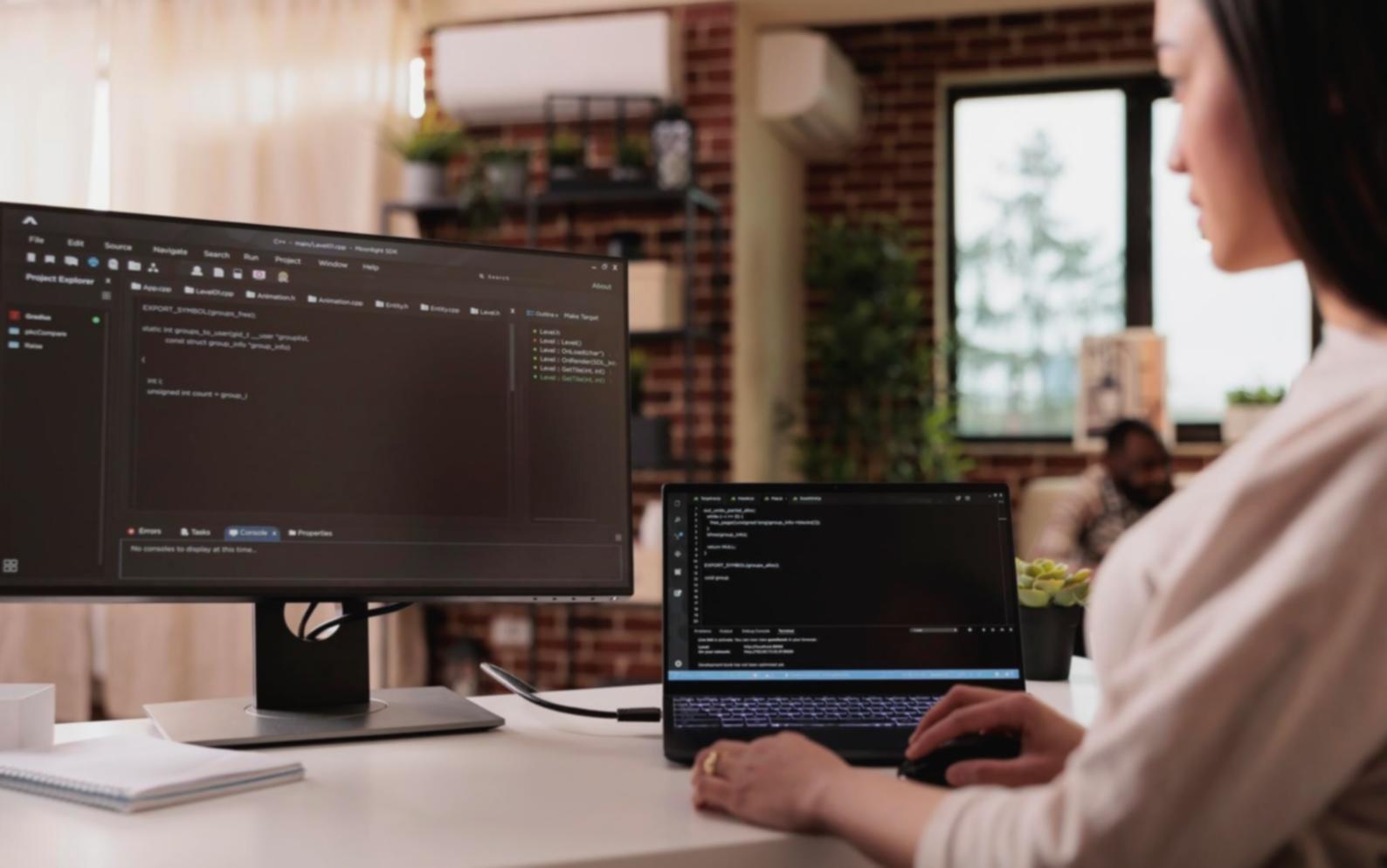 Development workspace with multiple monitors showing mobile app interfaces and code